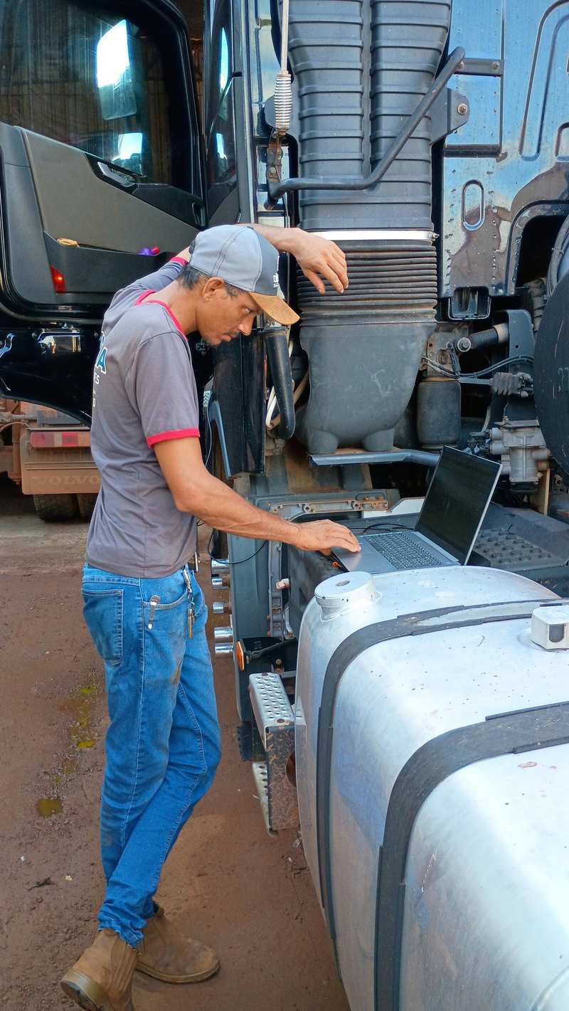 Mecânico da Mathia fazendo diagnóstico eletrônico com scanner conectado a um caminhão