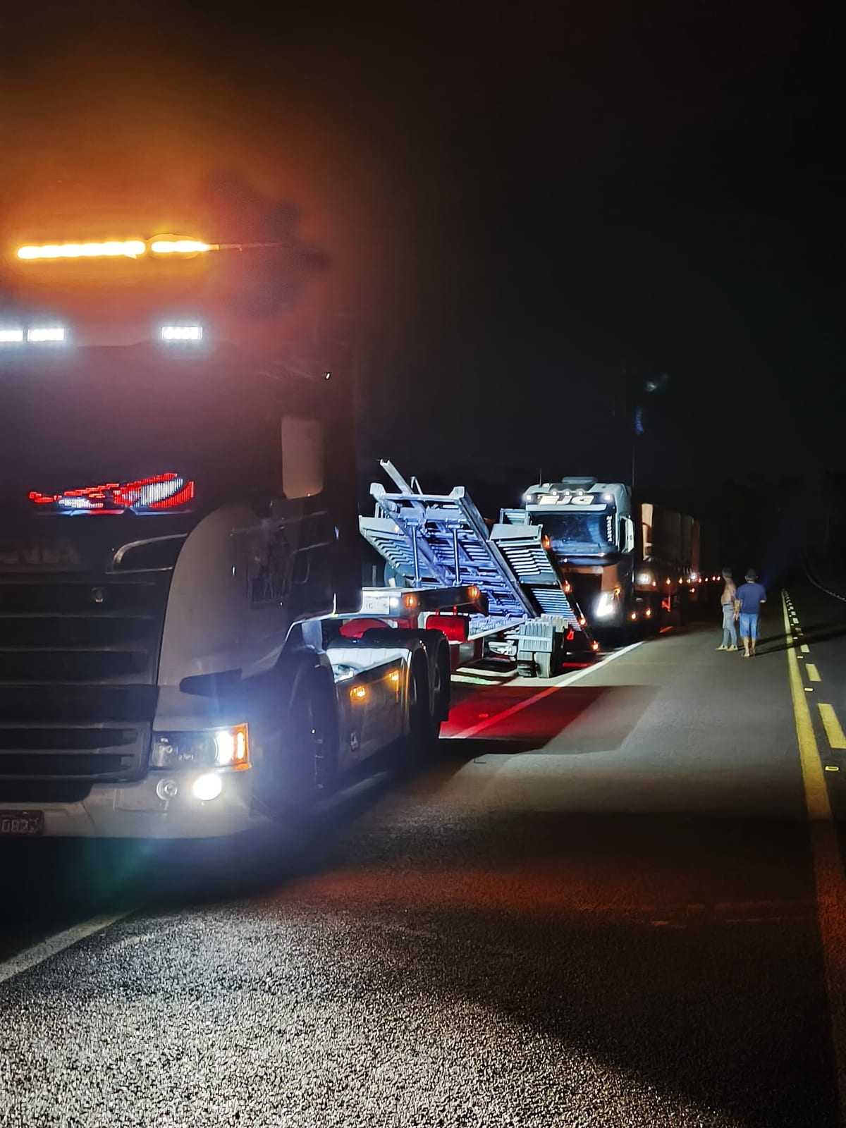 Guincho da Mathia à noite na rodovia, com giroflex aceso e a prancha inclinada para carregar o veículo