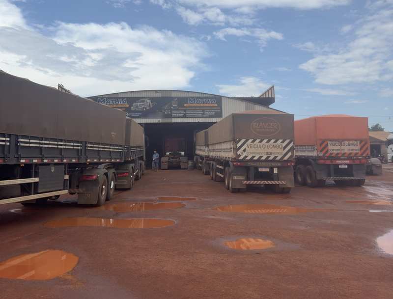 Pátio da Mathia na BR-158, em Confresa-MT, com caminhões e carretas diante do galpão com as placas atuais da oficina e do auto socorro